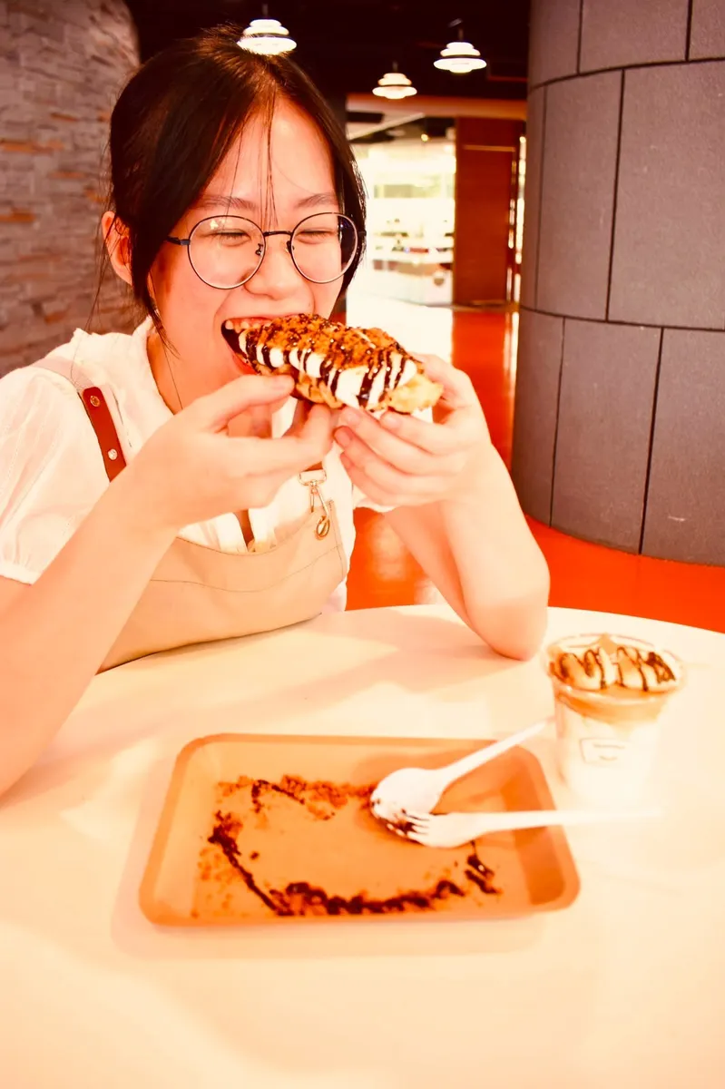 Girl eating a waffle wand at a night market