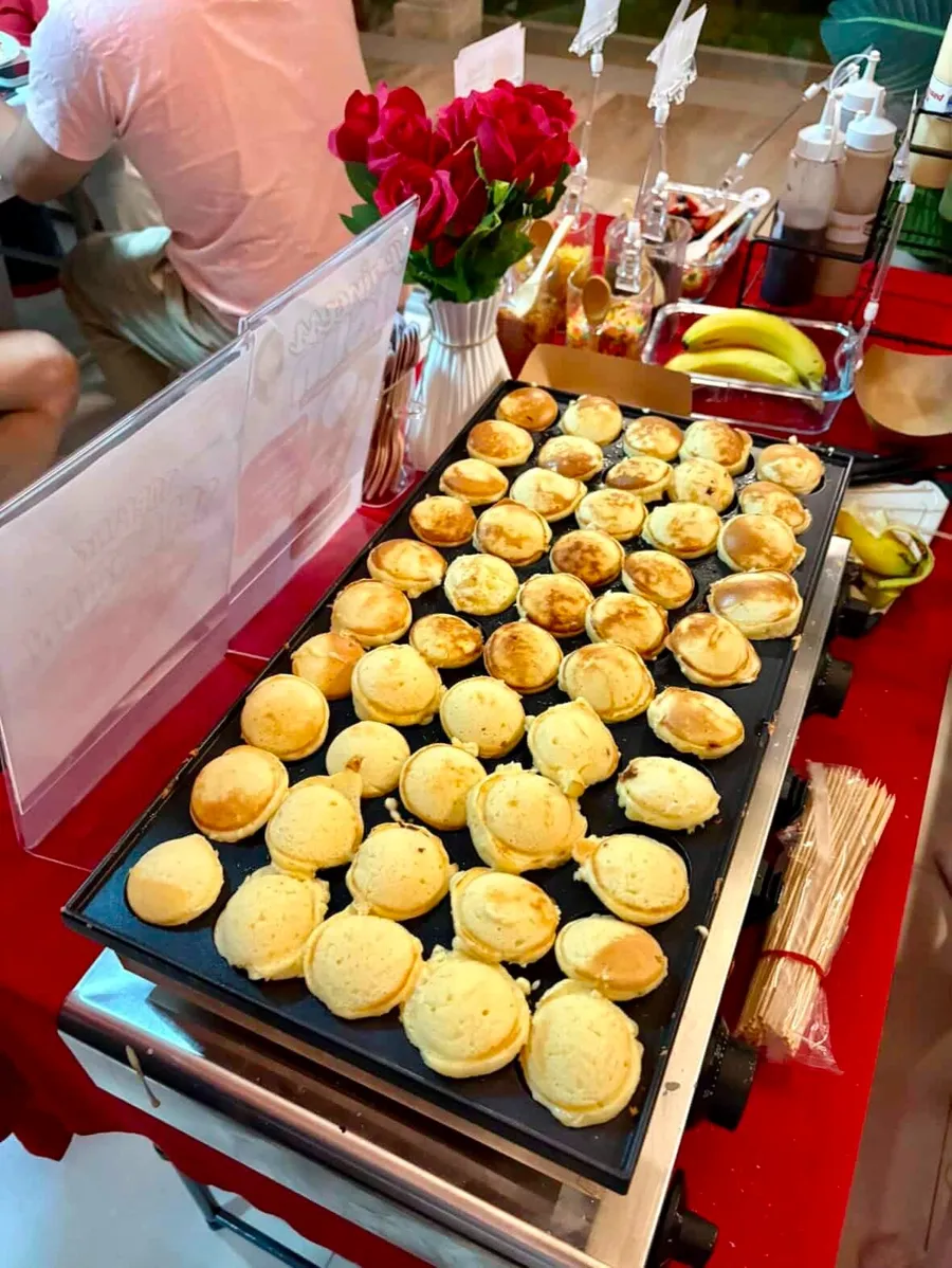 Mini pancakes cooking on a griddle at a live station