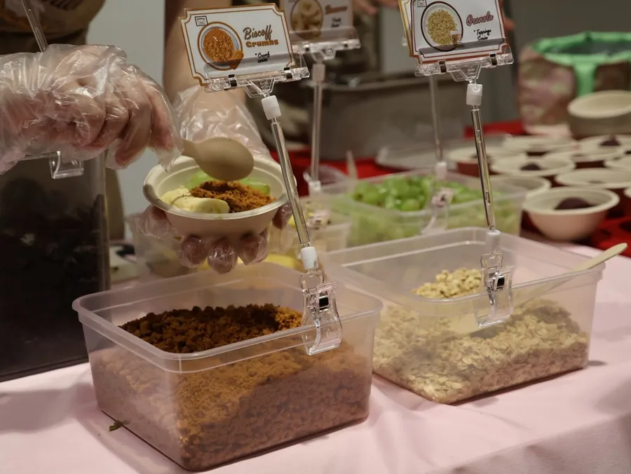 DIY toppings bar with sauces and crumbs at a Hummies live station